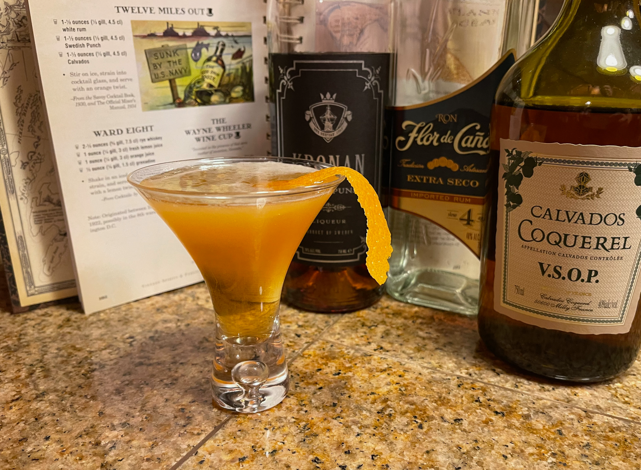 Twelve Miles Out - an orange colored cocktail in a conical glass